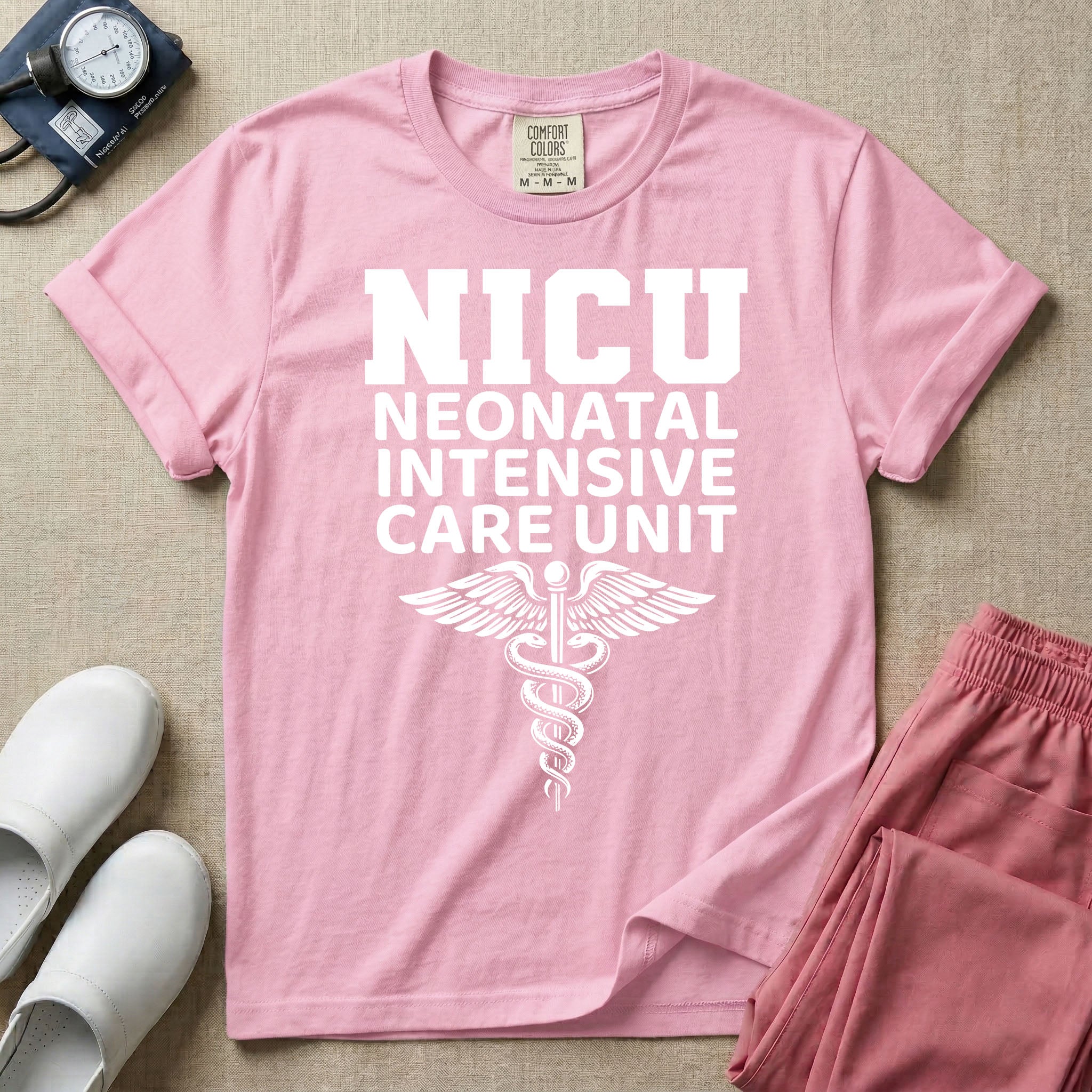 A t-shirt featuring the word NICU in large collegiate block letters above the spelled-out text Neonatal Intensive Care Unit and a medical caduceus symbol.