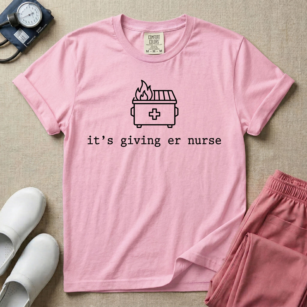 A funny minimalist ER nursing t-shirt featuring a simple white line drawing of a dumpster on fire with a medical cross on it, sitting above the lower-case typewriter text "it's giving er nurse".