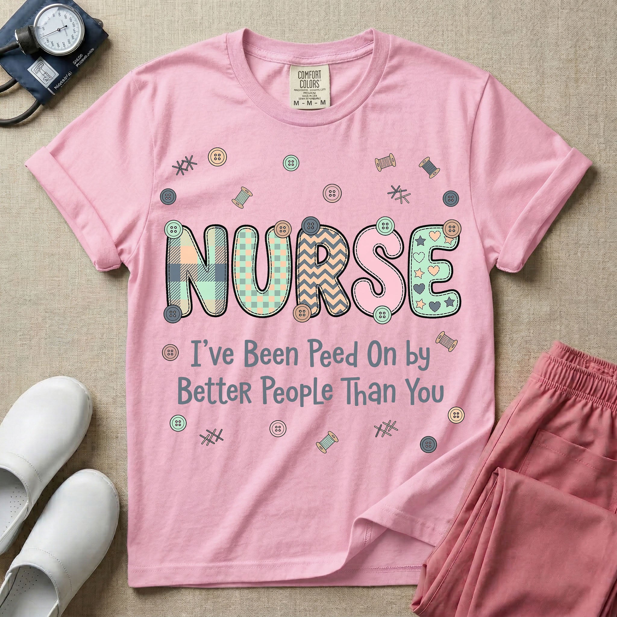 A humorous t-shirt for nurses featuring the word "NURSE" in colorful boho patterned letters above the funny phrase "I've Been Peed On by Better People Than You", surrounded by small abstract floral shapes.