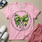 A graphic for a Neonatal Intensive Care Unit featuring a green camouflage bow with a stethoscope dangling from the bottom, a green heart in the center reading 'NICU', and the phrase 'One Lucky Nurse' repeating in a circle around the design.