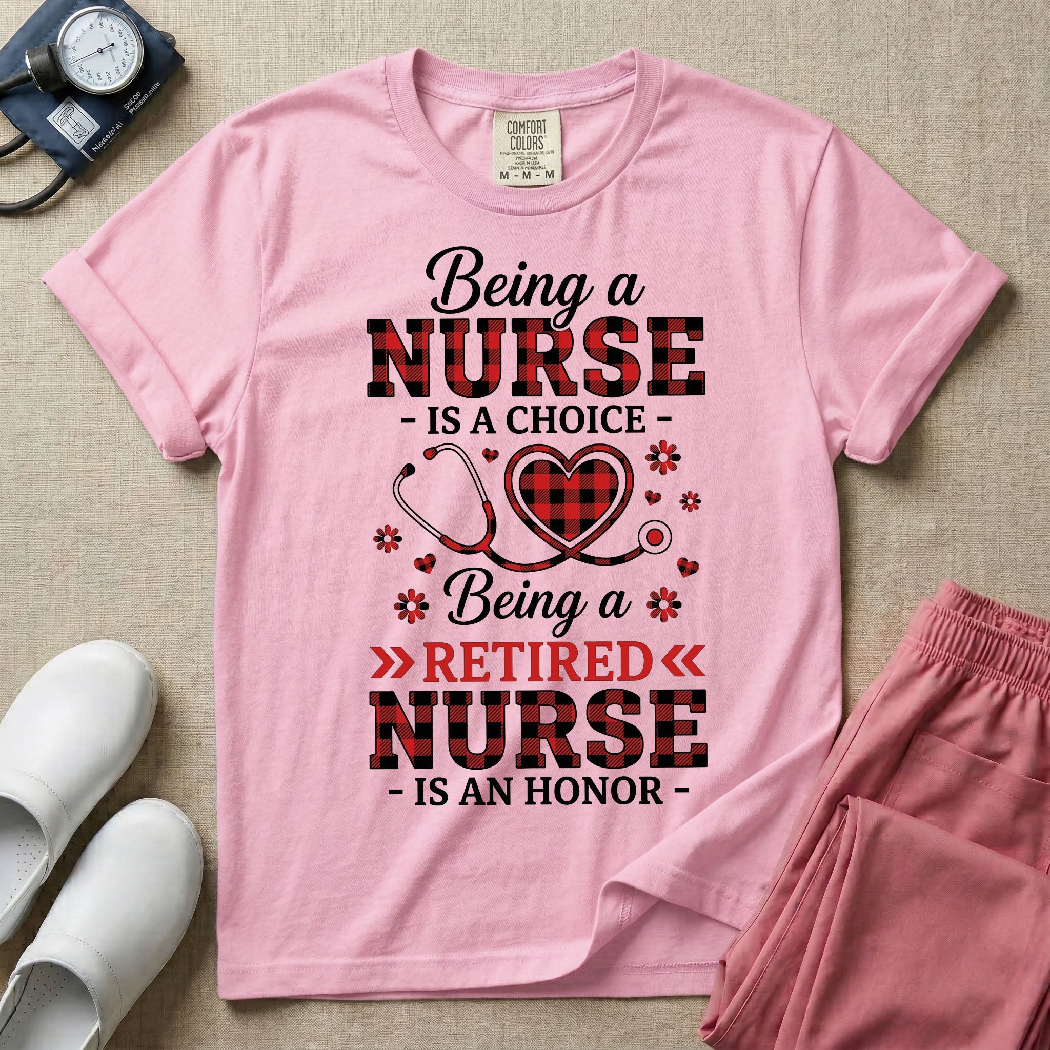 A t-shirt featuring the text Being a NURSE IS A CHOICE Being a RETIRED NURSE IS AN HONOR surrounding a central graphic of a red and black buffalo plaid heart intertwined with a stethoscope.