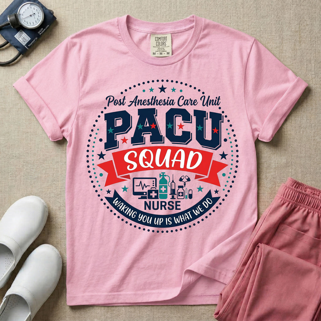 A t-shirt featuring a circular badge design with the text PACU SQUAD in block letters, medical icons like a heart monitor and stethoscope, and the phrase Waking You Up Is What We Do.