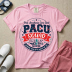 A t-shirt featuring a circular badge design with the text PACU SQUAD in block letters, medical icons like a heart monitor and stethoscope, and the phrase Waking You Up Is What We Do.