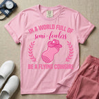 A humorous graphic tee for labor and delivery nurses featuring an illustration of a peanut ball wearing a cowboy hat, framed by laurel branches, along with the text "IN A WORLD FULL OF semi-fowlers BE A FLYING COWGIRL".