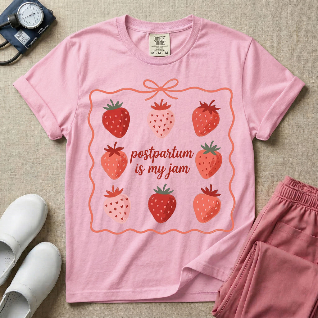 A funny and cute postpartum nursing t-shirt featuring the pun text "postpartum is my jam" surrounded by a graphic of red and pink strawberries, enclosed in a decorative wavy border with a bow at the top.
