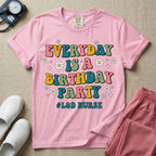 A retro graphic tee for labor and delivery nurses featuring bubble lettering that reads "EVERYDAY IS A BIRTHDAY PARTY #L&D NURSE" surrounded by small daisies and stars.