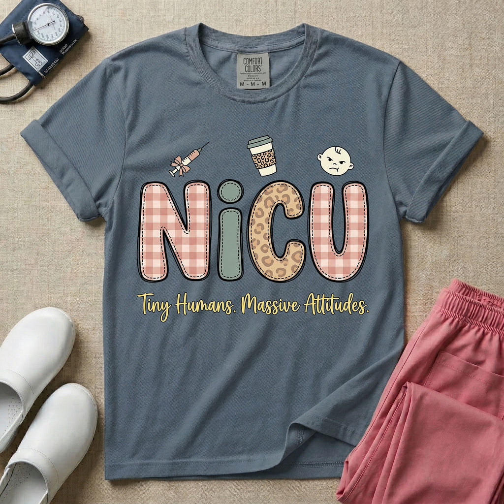 A humorous t-shirt for NICU nurses featuring the large text "NICU" in plaid and patterned letters with the phrase "Tiny Humans. Massive Attitudes." underneath, accompanied by small cute graphics of a syringe, an iced coffee cup, and a baby's face.
