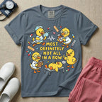 General nursing t-shirt featuring a chaotic group of cartoon ducklings dressed as medical professionals with the text "MOST DEFINITELY NOT ALL IN A ROW" on a sage green garment, in blue jean color.