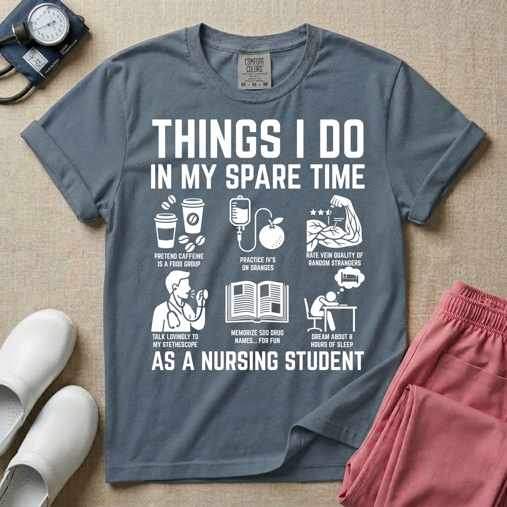 A t-shirt featuring the text THINGS I DO IN MY SPARE TIME AS A NURSING STUDENT surrounded by humorous line-art icons depicting studying, drinking coffee, and lacking sleep.