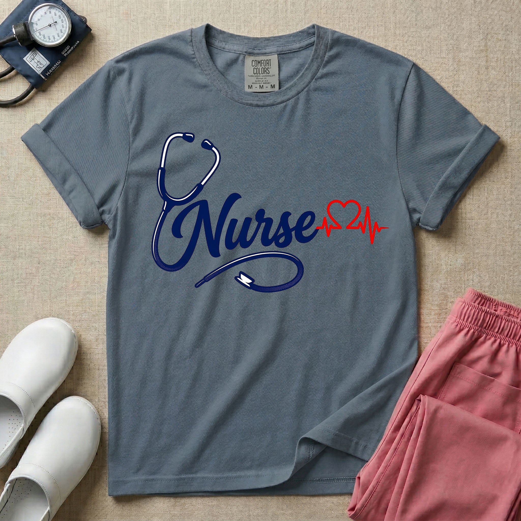General nursing t-shirt with a minimalist cursive Nurse text integrated with a navy blue stethoscope and a red heartbeat graphic.
