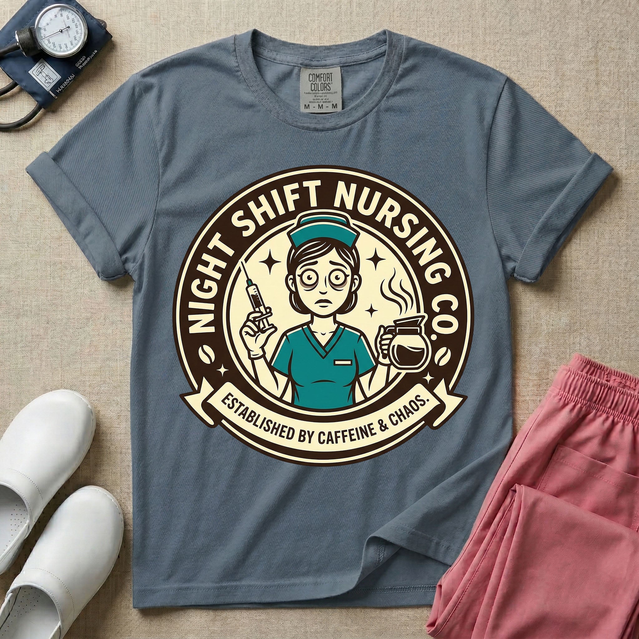 General nursing night shift nurse t-shirt with a retro vintage exhausted nurse holding coffee and a syringe established by caffeine and chaos graphic in blue jean color.