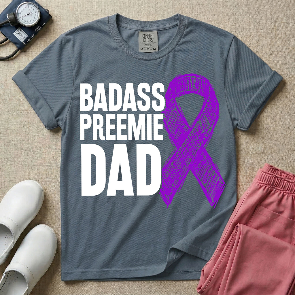 A graphic for the Neonatal Intensive Care Unit featuring the stacked, bold white text 'BADASS PREEMIE DAD' next to a large, textured purple awareness ribbon.