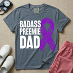 A graphic for the Neonatal Intensive Care Unit featuring the stacked, bold white text 'BADASS PREEMIE DAD' next to a large, textured purple awareness ribbon.