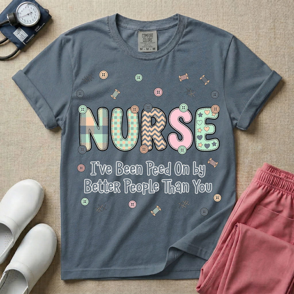 A humorous t-shirt for nurses featuring the word "NURSE" in colorful boho patterned letters above the funny phrase "I've Been Peed On by Better People Than You", surrounded by small abstract floral shapes.