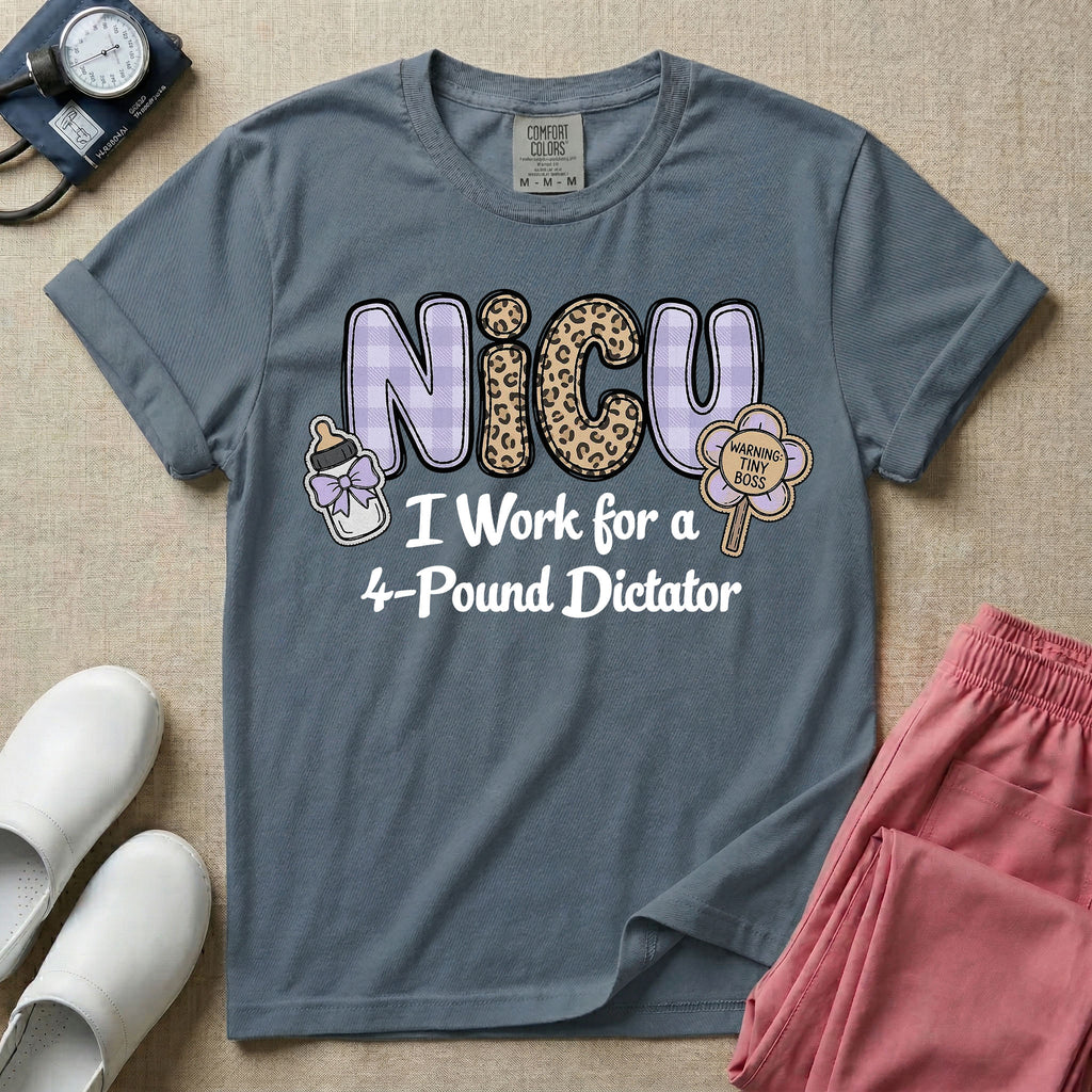 A funny t-shirt for NICU nurses featuring the text "NICU I Work for a 4-Pound Dictator" designed with purple plaid and leopard print letters, accompanied by graphics of a baby bottle with a bow and a rattle that says "WARNING: TINY BOSS".