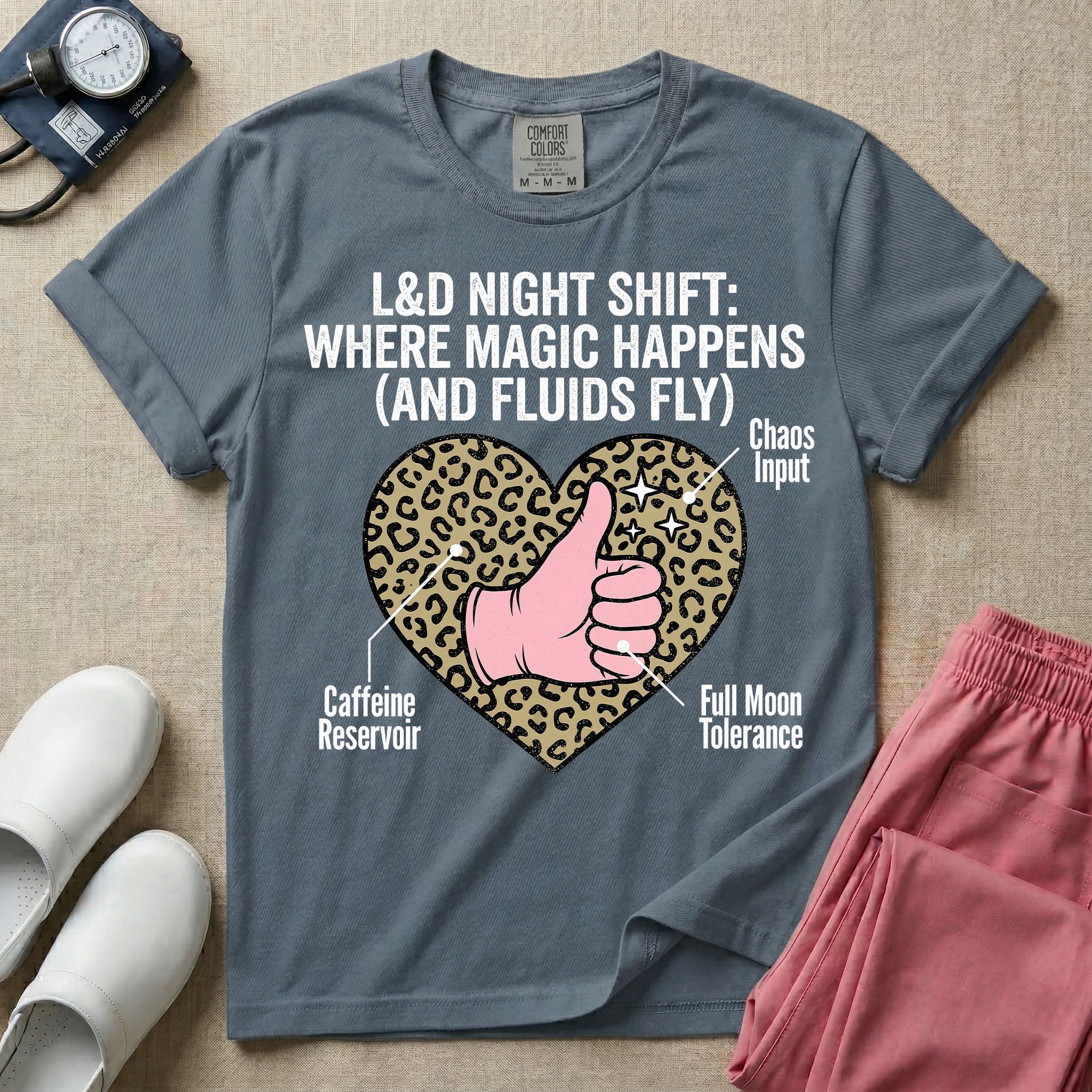 Labor and Delivery L&D nursing t-shirt featuring a leopard print heart diagram with a gloved thumbs-up and the text "L&D NIGHT SHIFT: WHERE MAGIC HAPPENS (AND FLUIDS FLY)"