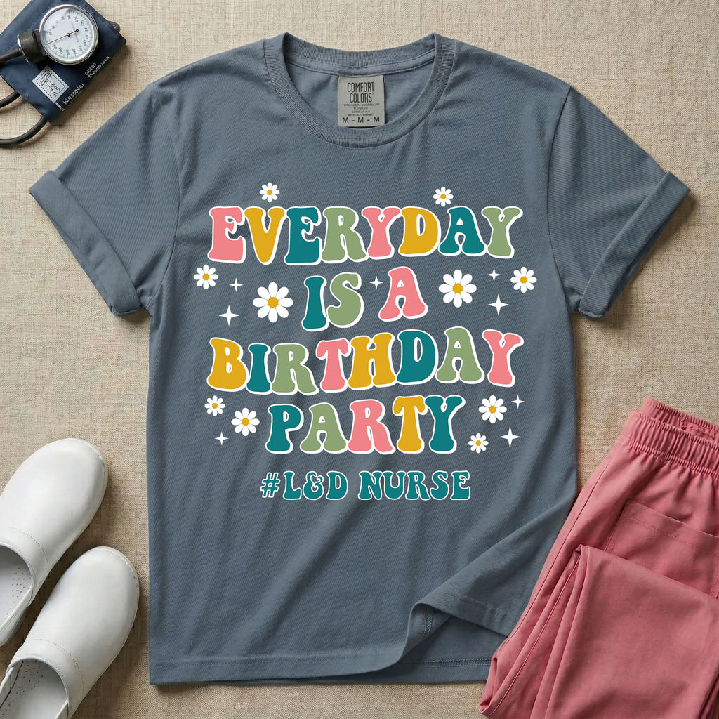 A retro graphic tee for labor and delivery nurses featuring bubble lettering that reads "EVERYDAY IS A BIRTHDAY PARTY #L&D NURSE" surrounded by small daisies and stars.