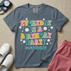 A retro graphic tee for labor and delivery nurses featuring bubble lettering that reads "EVERYDAY IS A BIRTHDAY PARTY #L&D NURSE" surrounded by small daisies and stars.