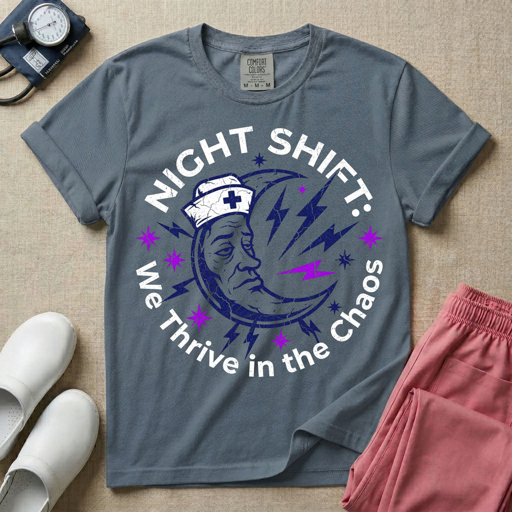 General nursing night shift nurse t-shirt with a retro purple moon wearing a nurse cap and we thrive in the chaos graphic in blue jean color.