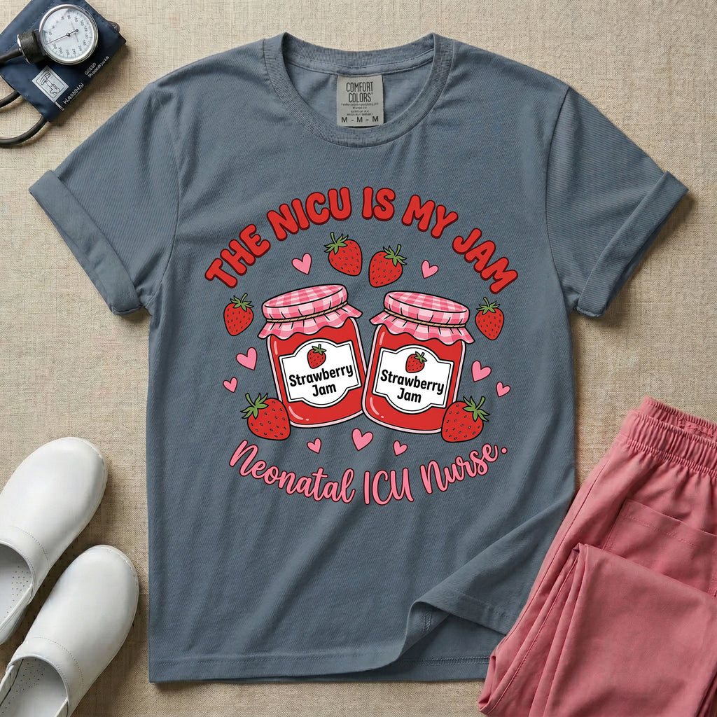 A t-shirt featuring two jars of strawberry jam surrounded by small hearts and strawberries with the text THE NICU IS MY JAM arched above and Neonatal ICU Nurse written in a retro script below.