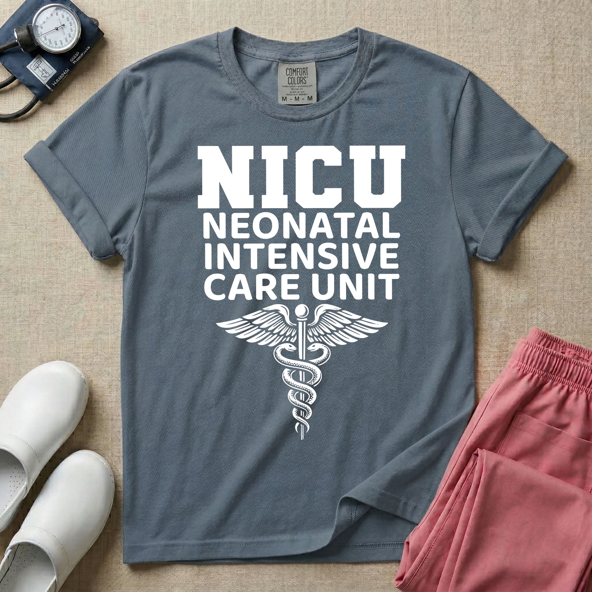 A t-shirt featuring the word NICU in large collegiate block letters above the spelled-out text Neonatal Intensive Care Unit and a medical caduceus symbol.