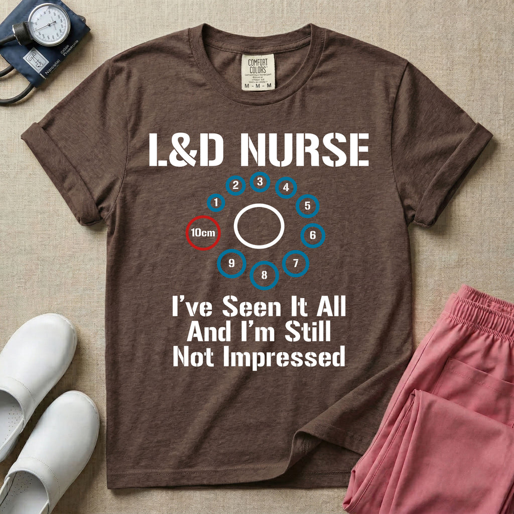 A humorous Labor and Delivery nurse t-shirt featuring a cervical dilation chart graphic highlighting 10cm, with the text "L&D NURSE" at the top and "I've Seen It All And I'm Still Not Impressed" at the bottom.