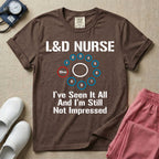 A humorous Labor and Delivery nurse t-shirt featuring a cervical dilation chart graphic highlighting 10cm, with the text "L&D NURSE" at the top and "I've Seen It All And I'm Still Not Impressed" at the bottom.