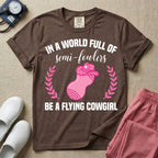 A humorous graphic tee for labor and delivery nurses featuring an illustration of a peanut ball wearing a cowboy hat, framed by laurel branches, along with the text "IN A WORLD FULL OF semi-fowlers BE A FLYING COWGIRL".