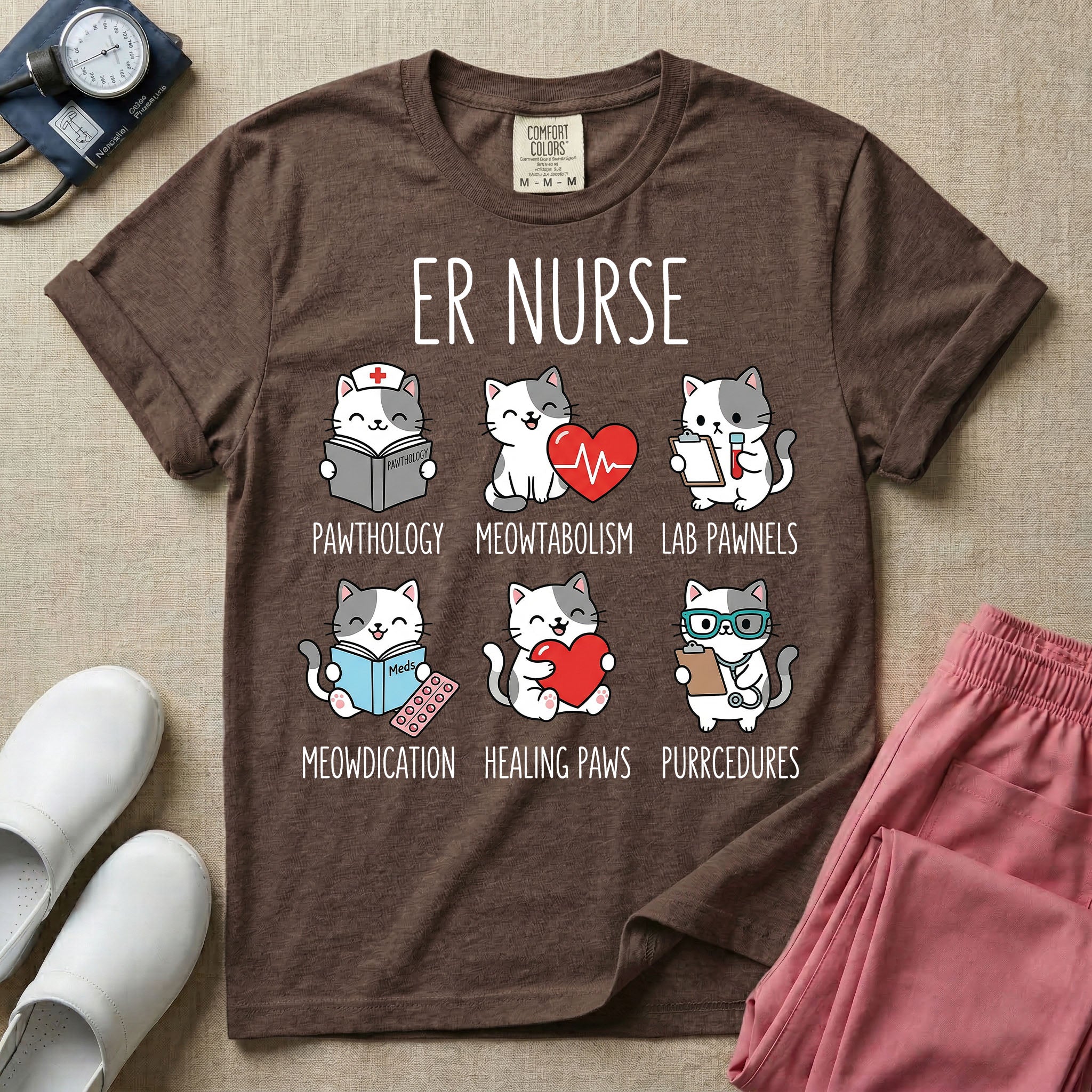 A funny t-shirt for emergency room nurses featuring the text "ER NURSE" above a grid of six cute cartoon cats demonstrating medical puns, including a cat reading for "PAWTHOLOGY", a cat with an ECG heart for "MEOWTABOLISM", a cat holding a test tube for "LAB PAWNELS", a cat with pills for "MEOWDICATION", a cat holding a heart for "HEALING PAWS", and a cat with a stethoscope for "PURRCEDURES".