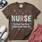 A humorous t-shirt for nurses featuring the word "NURSE" in colorful boho patterned letters above the funny phrase "I've Been Peed On by Better People Than You", surrounded by small abstract floral shapes.