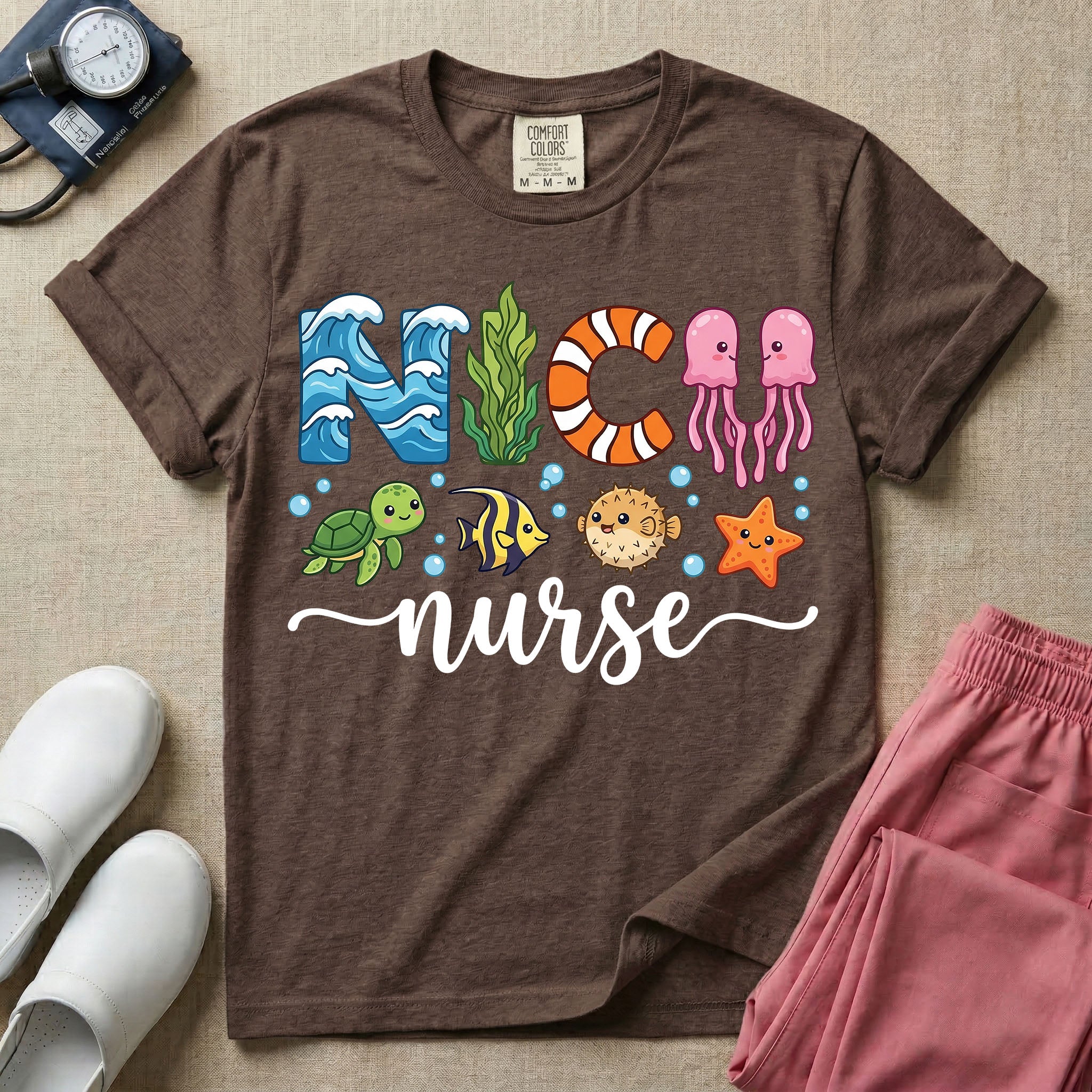 A cute t-shirt for NICU nurses featuring the text "NICU nurse" where the letters are designed with ocean elements like waves, seaweed, and a jellyfish, surrounded by under the sea creatures including a sea turtle, tropical fish, pufferfish, and starfish.