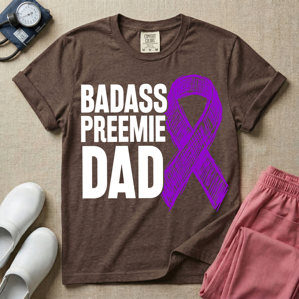 A graphic for the Neonatal Intensive Care Unit featuring the stacked, bold white text 'BADASS PREEMIE DAD' next to a large, textured purple awareness ribbon.