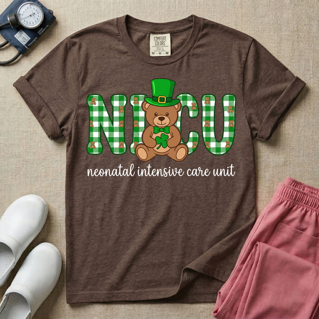 A graphic for a Neonatal Intensive Care Unit featuring the word 'NICU' in green and white plaid patterned letters, with a cute brown teddy bear wearing a leprechaun hat and holding a shamrock sitting in the middle, and the cursive text 'neonatal intensive care unit' underneath.