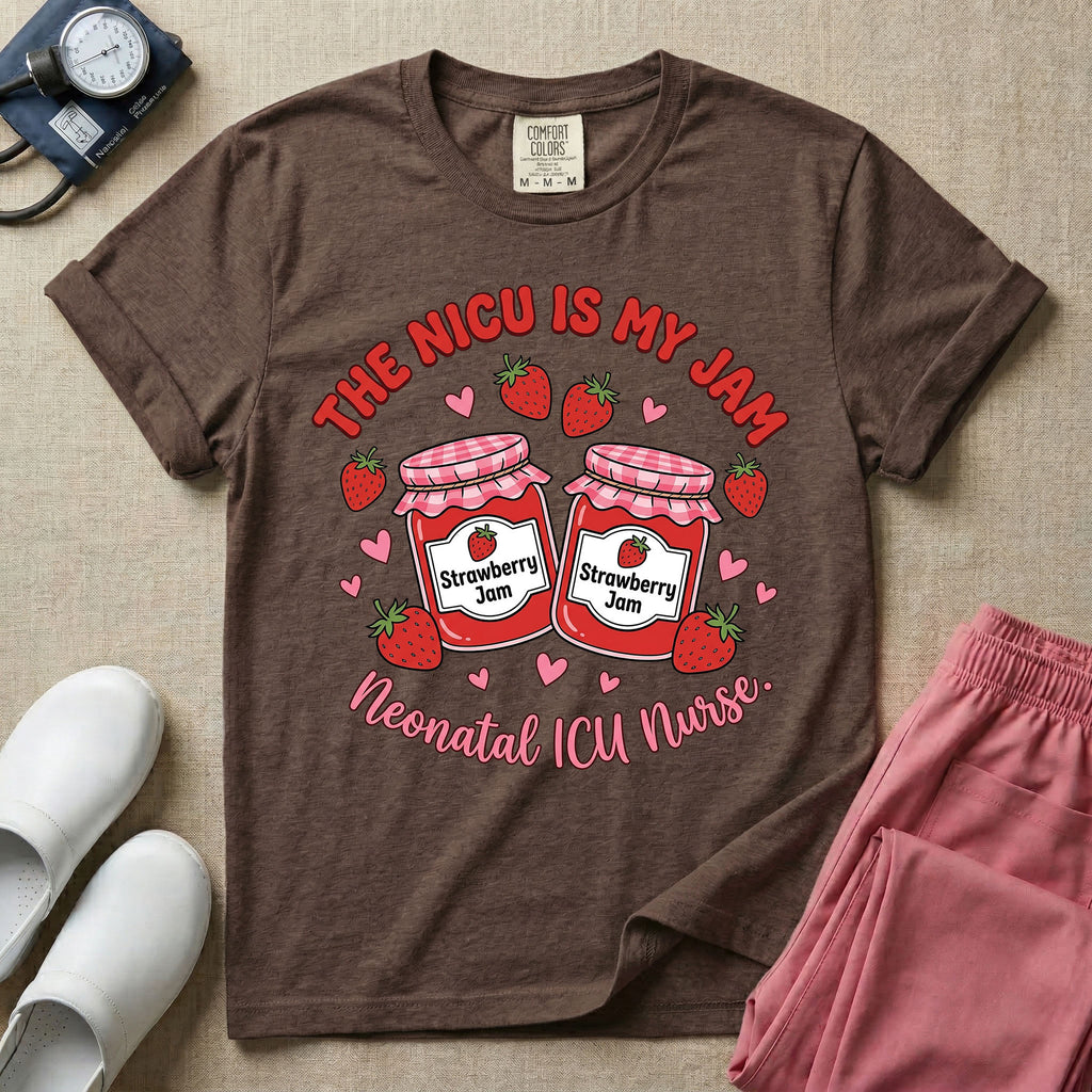 A t-shirt featuring two jars of strawberry jam surrounded by small hearts and strawberries with the text THE NICU IS MY JAM arched above and Neonatal ICU Nurse written in a retro script below.