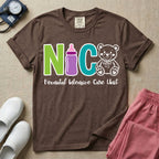 A t-shirt featuring the acronym NICU creatively spelled out using a green letter N, a purple baby bottle, a teal letter C, and a white outlined teddy bear, with the words Neonatal Intensive Care Unit written in cursive script below.