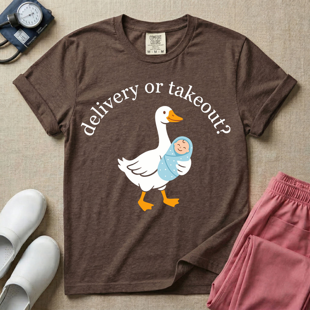 A funny L&D nursing t-shirt featuring a graphic of a white silly goose carrying a baby in a blue swaddle in its beak, surrounded by the humorous arched text "delivery or takeout?".