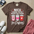 A Valentine's Day themed graphic for a Neonatal Intensive Care Unit featuring the text 'NICU WHERE YOU'RE NEVER TOO YOUNG' stacked above three to-go coffee cups decorated with heart patterns, with 'for Caffeine' written in script at the bottom, all surrounded by small red and pink hearts.