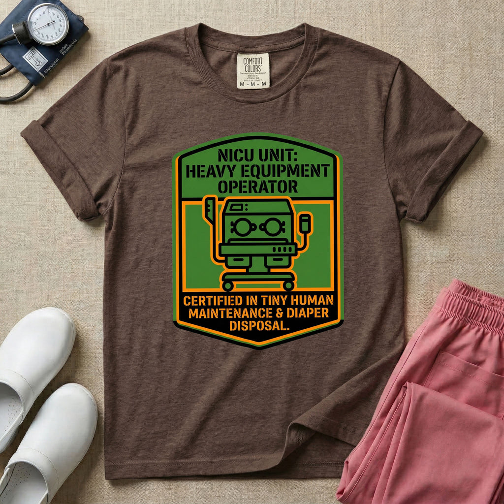 A graphic resembling a patch with green borders and orange inner sections featuring an illustration of a medical incubator in the center, with the text 'NICU UNIT: HEAVY EQUIPMENT OPERATOR' at the top and 'CERTIFIED IN TINY HUMAN MAINTENANCE & DIAPER DISPOSAL' at the bottom.