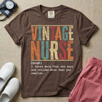 A humorous General Nursing graphic featuring large distressed retro-style block letters spelling VINTAGE NURSE, positioned above a dictionary-style definition in white typewriter font that reads (noun) 1. knows more than she says and notices more than you realize.