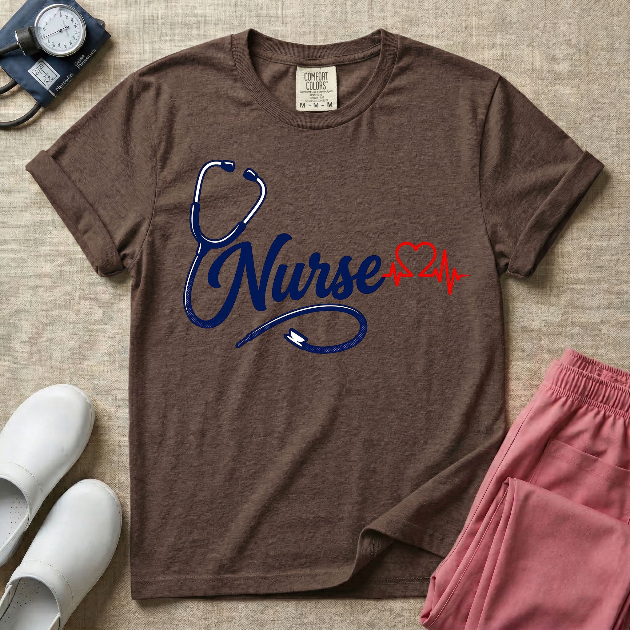 General nursing t-shirt with a minimalist cursive Nurse text integrated with a navy blue stethoscope and a red heartbeat graphic.
