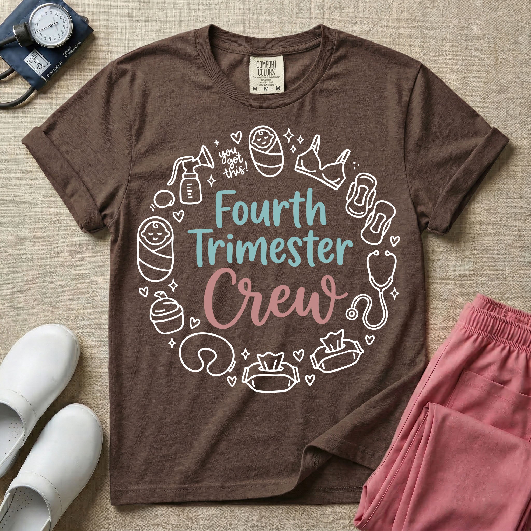 A postpartum nursing t-shirt featuring the stacked text "Fourth Trimester Crew" in blue and pink retro fonts, surrounded by a circular border of white minimalist line drawings depicting newborn and postpartum care items including a breast pump, swaddled baby, maternity bra, maxi pad, stethoscope, wipes, and a nursing pillow.