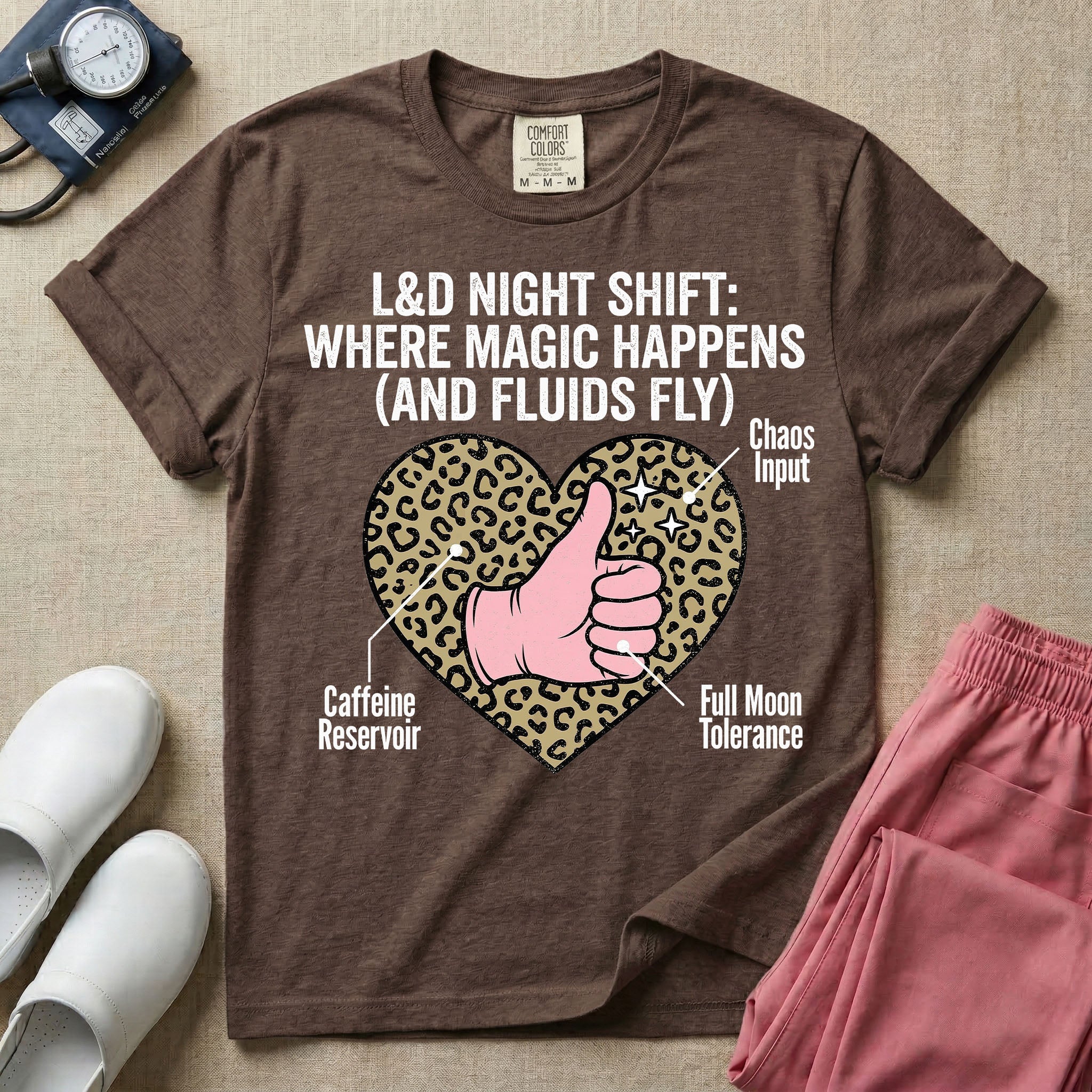 Labor and Delivery L&D nursing t-shirt featuring a leopard print heart diagram with a gloved thumbs-up and the text "L&D NIGHT SHIFT: WHERE MAGIC HAPPENS (AND FLUIDS FLY)"