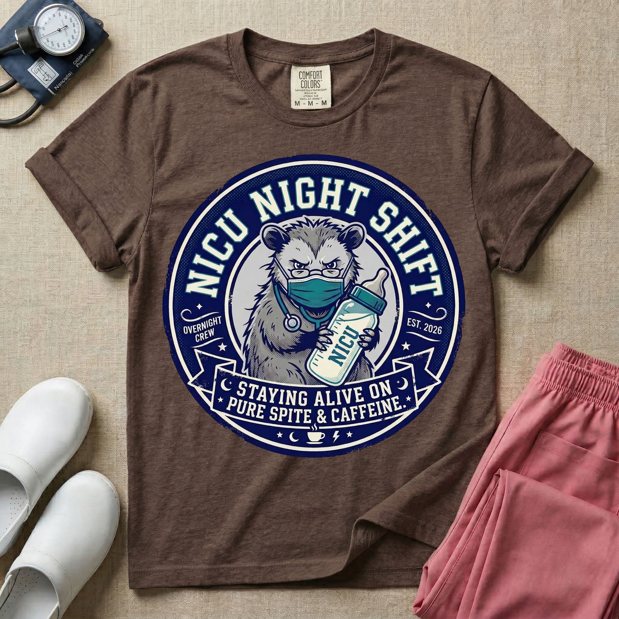 A humorous graphic for a Neonatal Intensive Care Unit featuring a circular design with an illustration of a tired raccoon wearing a medical face mask and holding a baby bottle labeled 'NICU', surrounded by the text 'NICU NIGHT SHIFT' at the top and 'STAYING ALIVE ON PURE SPITE & CAFFEINE' at the bottom.