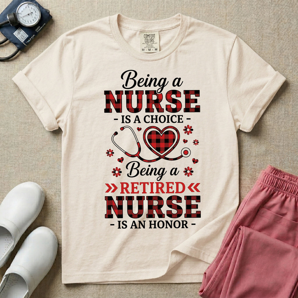 A t-shirt featuring the text Being a NURSE IS A CHOICE Being a RETIRED NURSE IS AN HONOR surrounding a central graphic of a red and black buffalo plaid heart intertwined with a stethoscope.