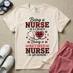A t-shirt featuring the text Being a NURSE IS A CHOICE Being a RETIRED NURSE IS AN HONOR surrounding a central graphic of a red and black buffalo plaid heart intertwined with a stethoscope.