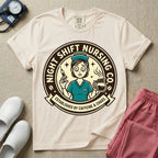 General nursing night shift nurse t-shirt with a retro vintage exhausted nurse holding coffee and a syringe established by caffeine and chaos graphic in ivory color.