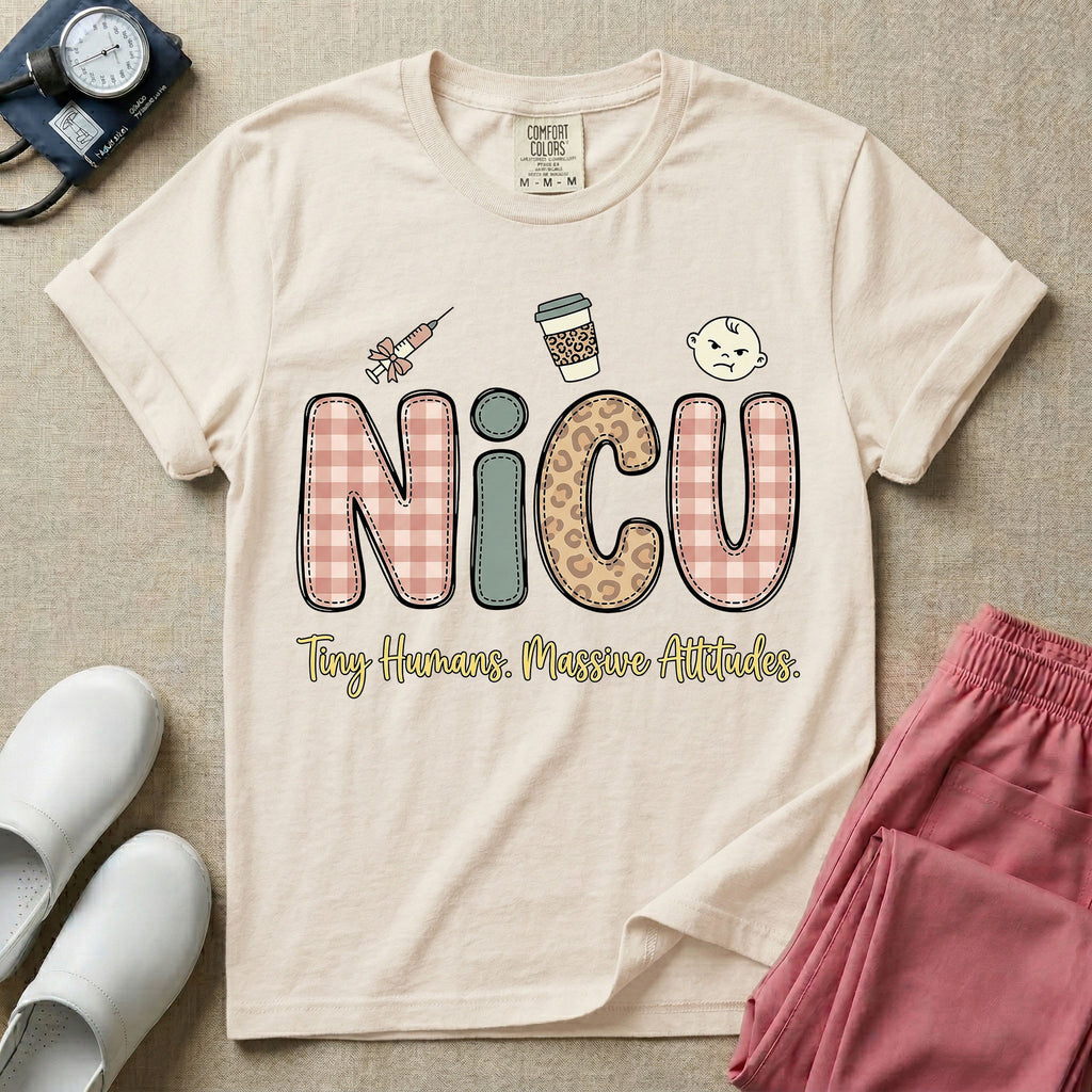 A humorous t-shirt for NICU nurses featuring the large text "NICU" in plaid and patterned letters with the phrase "Tiny Humans. Massive Attitudes." underneath, accompanied by small cute graphics of a syringe, an iced coffee cup, and a baby's face.