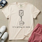 A funny minimalist ER nursing t-shirt featuring a white line drawing of an IV bag containing a coffee bean dripping into a mug labeled "night shift", sitting above the lower-case typewriter text "it's giving er nurse".