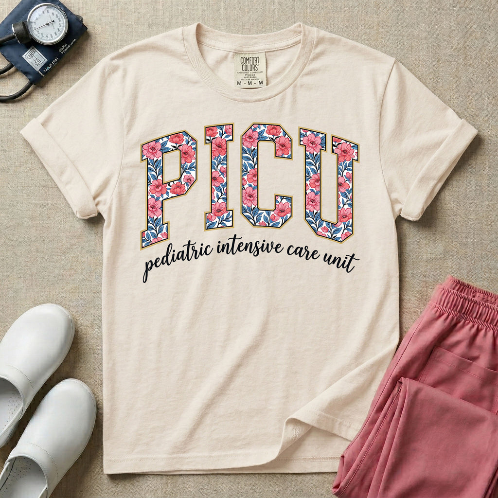 A boho pediatric intensive care nursing t-shirt featuring the large block text "PICU" filled with a decorative floral pattern, positioned above the cursive white text "pediatric intensive care unit".