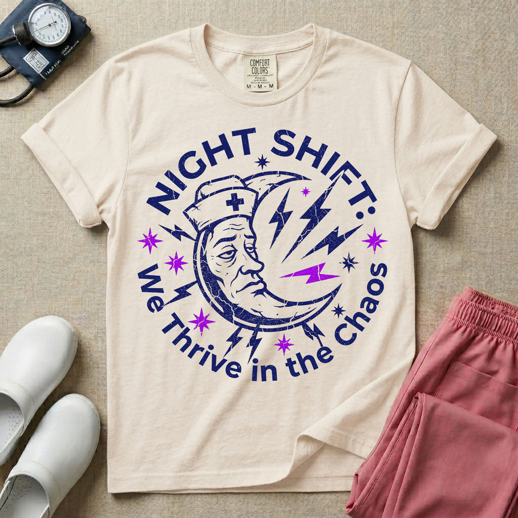 General nursing night shift nurse t-shirt with a retro purple moon wearing a nurse cap and we thrive in the chaos graphic in ivory color.